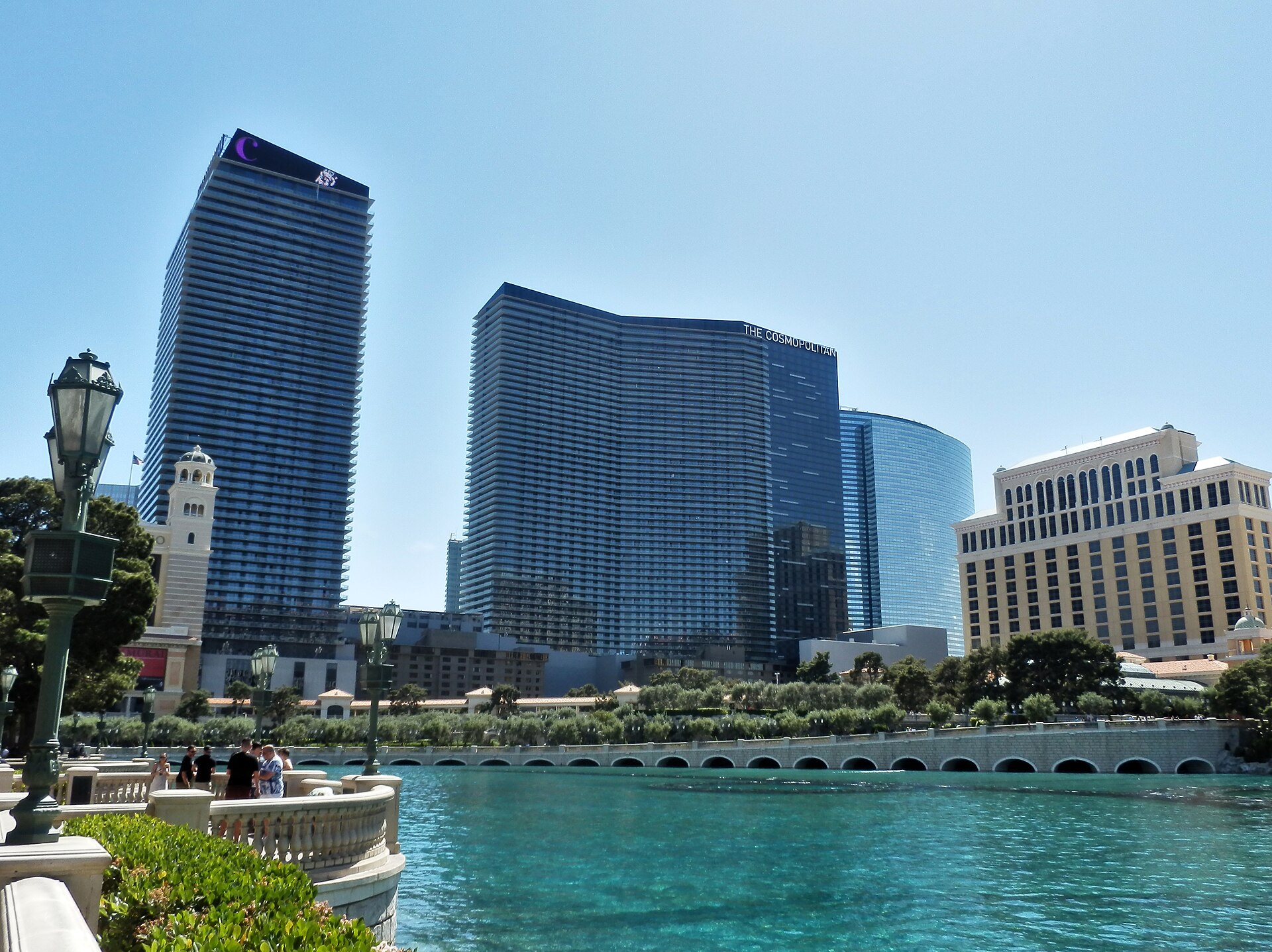 The Cosmopolitan's two glass towers rising beyond the Bellagio lake on a sunny day