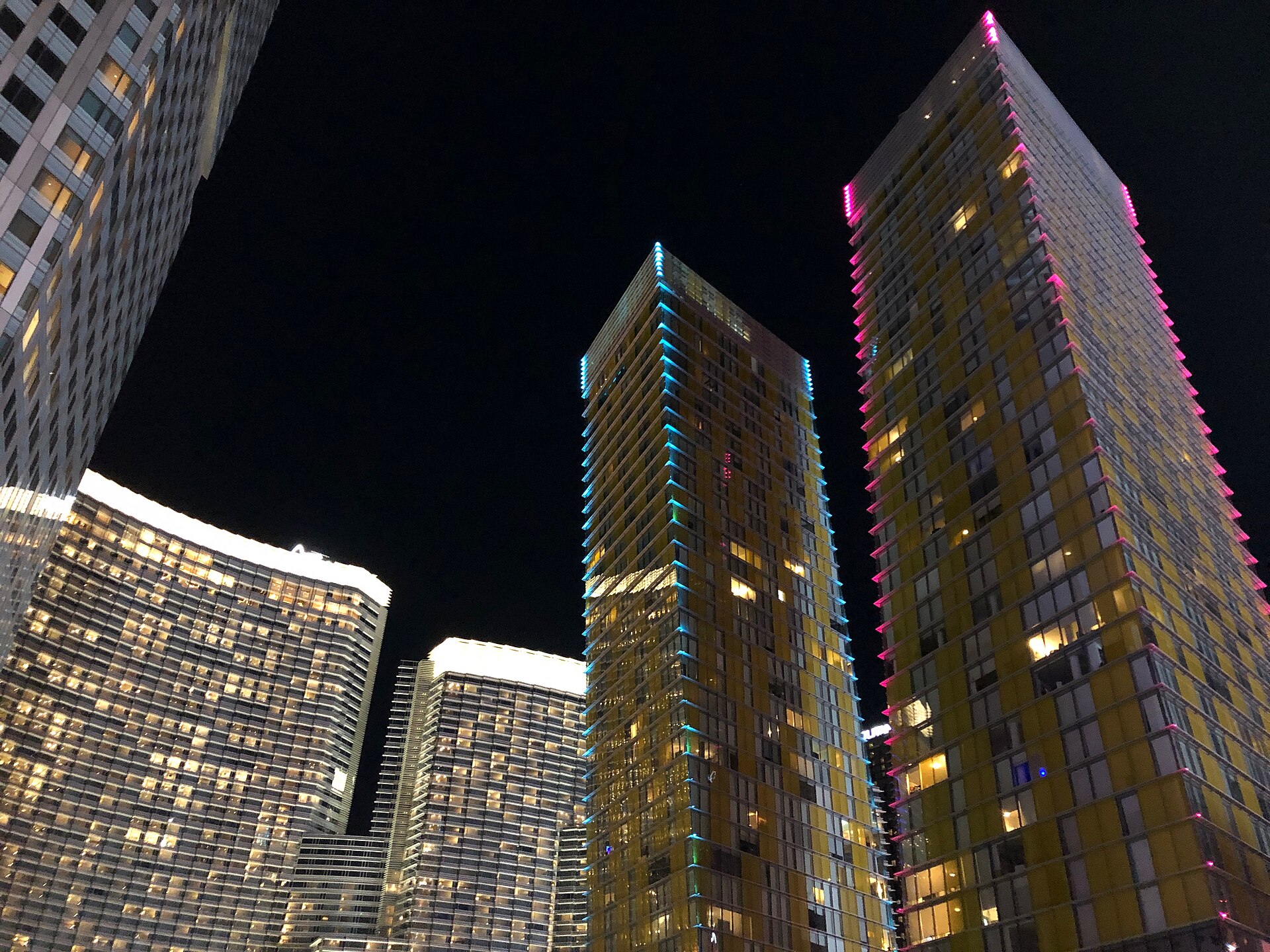ARIA hotel towers and the leaning Veer Towers lit in color at night in CityCenter