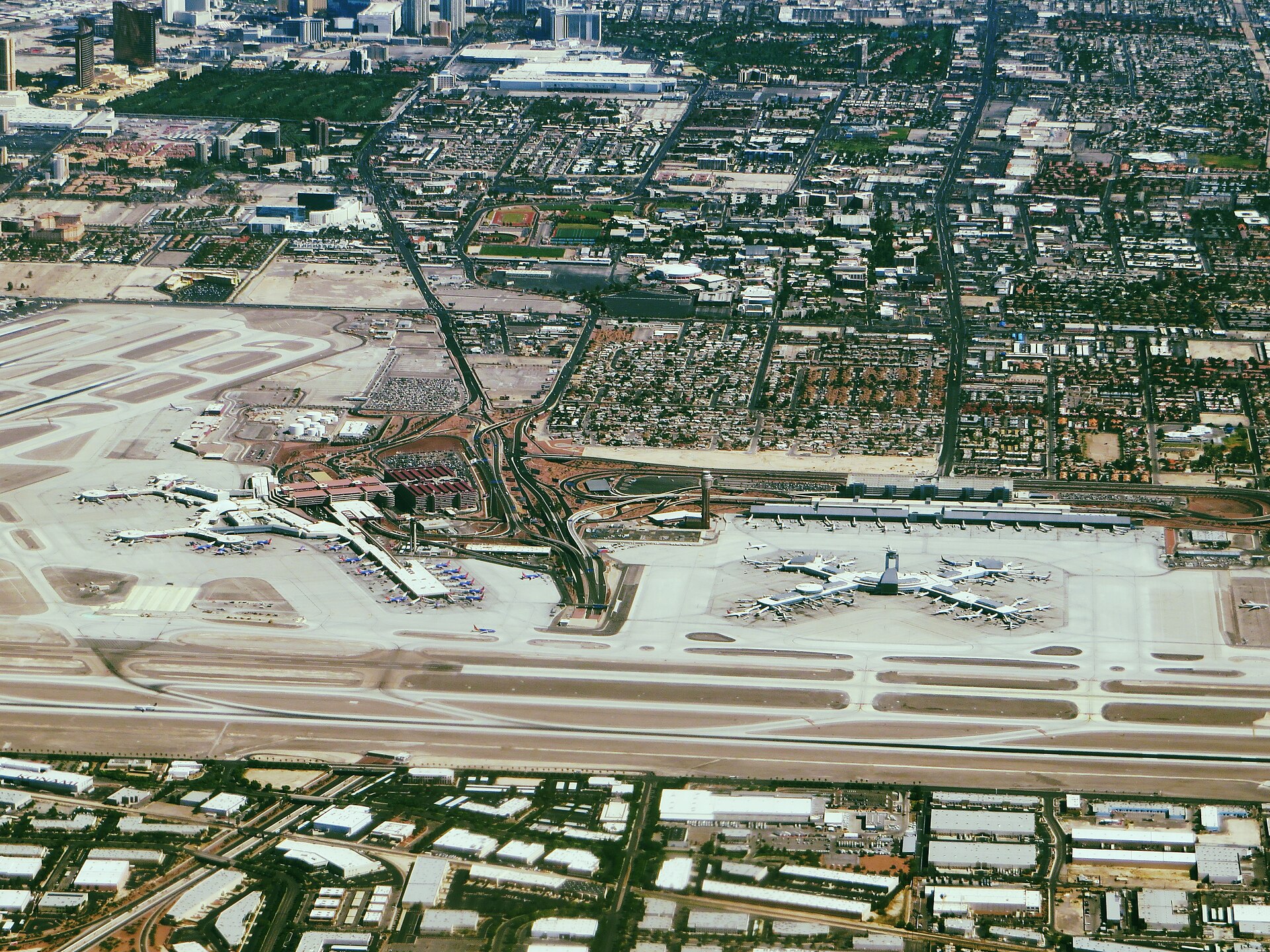 Aerial view of Harry Reid International Airport in Las Vegas with the Strip behind it