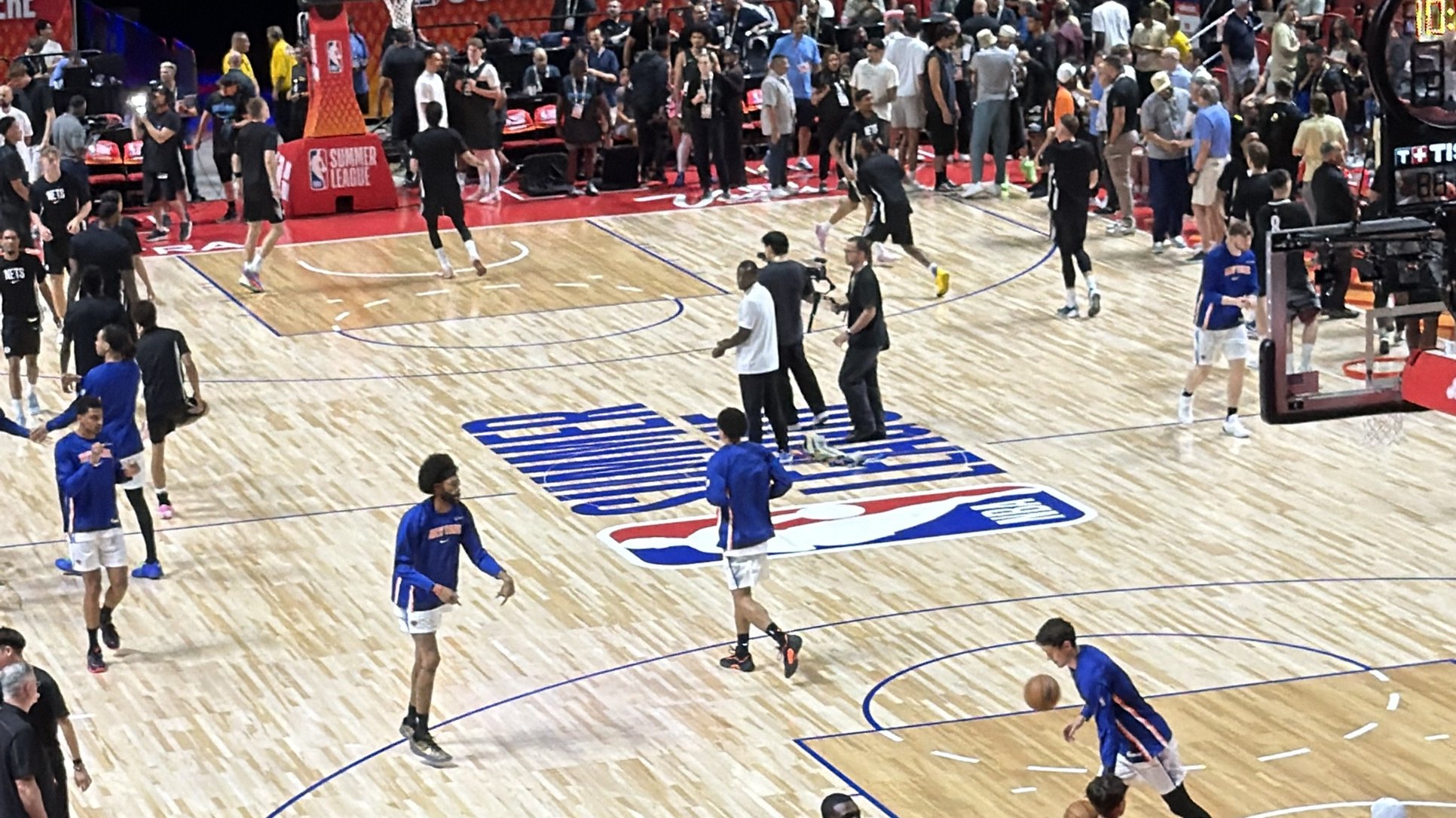 NBA Summer League warm-ups at the Thomas and Mack Center in Las Vegas, players in blue and black shooting around the court logo