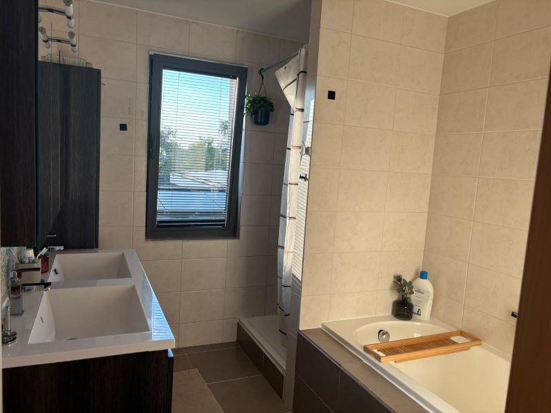 Badkamer met dubbele lavabo, douche en ligbad
