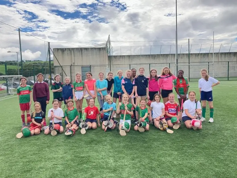 Camogie Club members with their hurleys on the astro