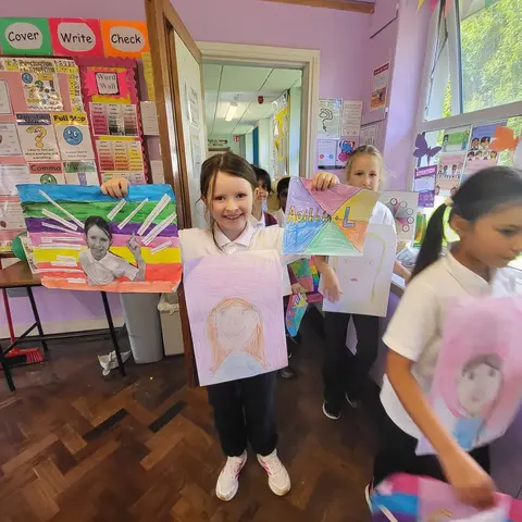 3rd Class pupils holding up their Getting to Know Me artwork (photo 6 of 14)
