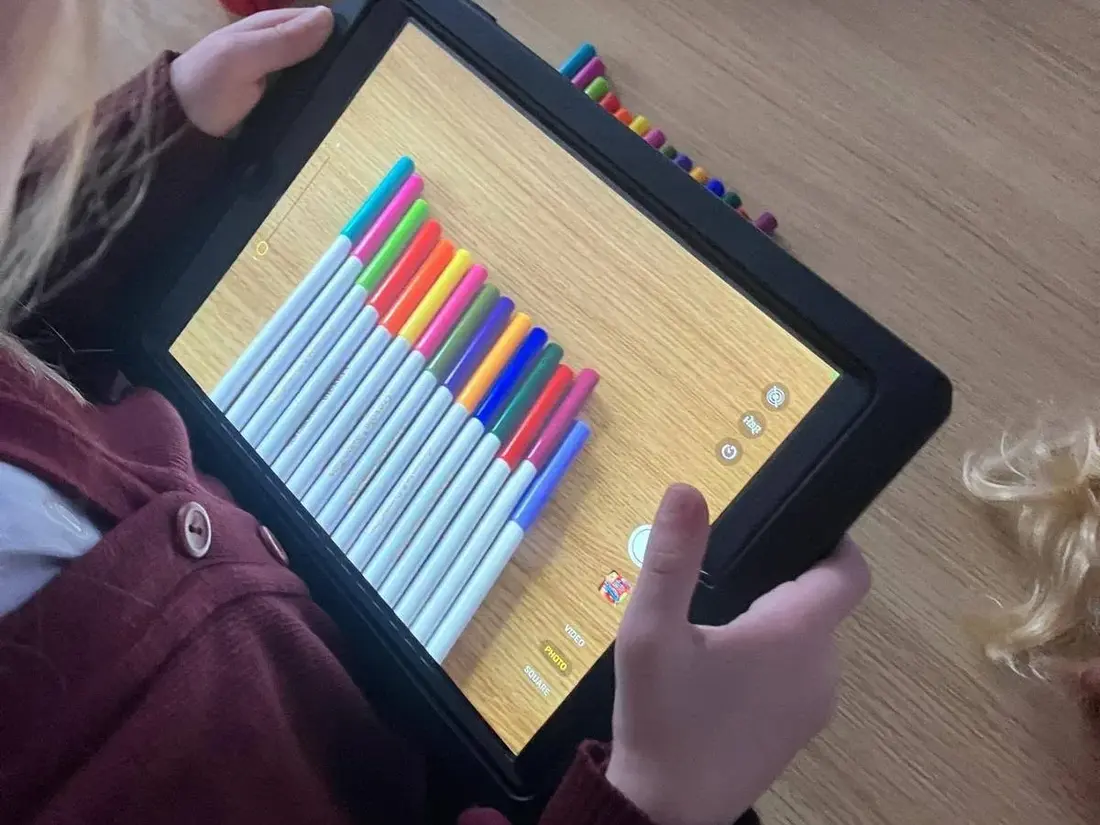 A pupil photographing a row of markers with a tablet