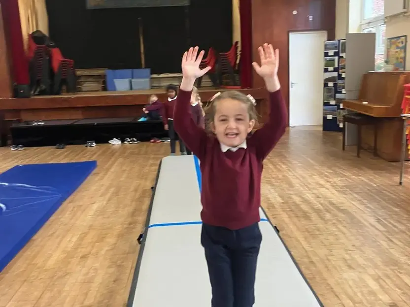 A pupil on a gymnastics mat in the school hall