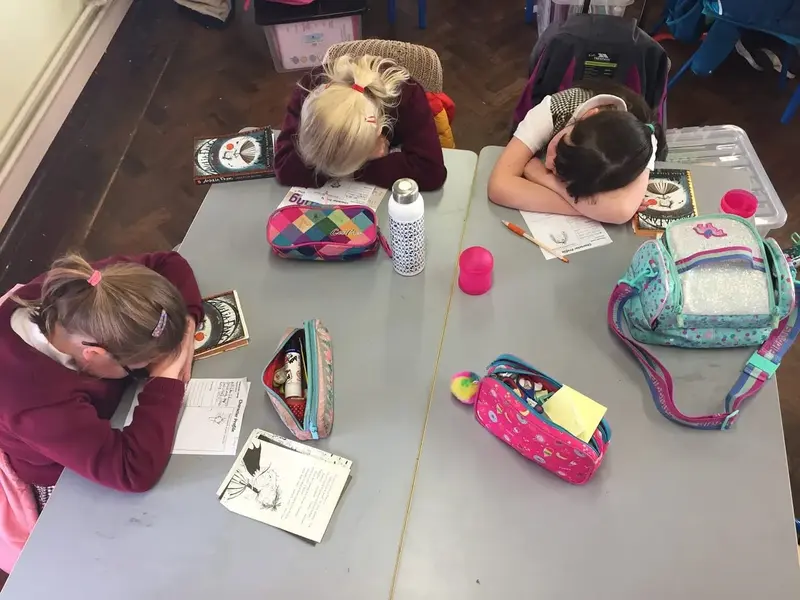 Pupils resting their heads on their desks during a quiet mindful moment