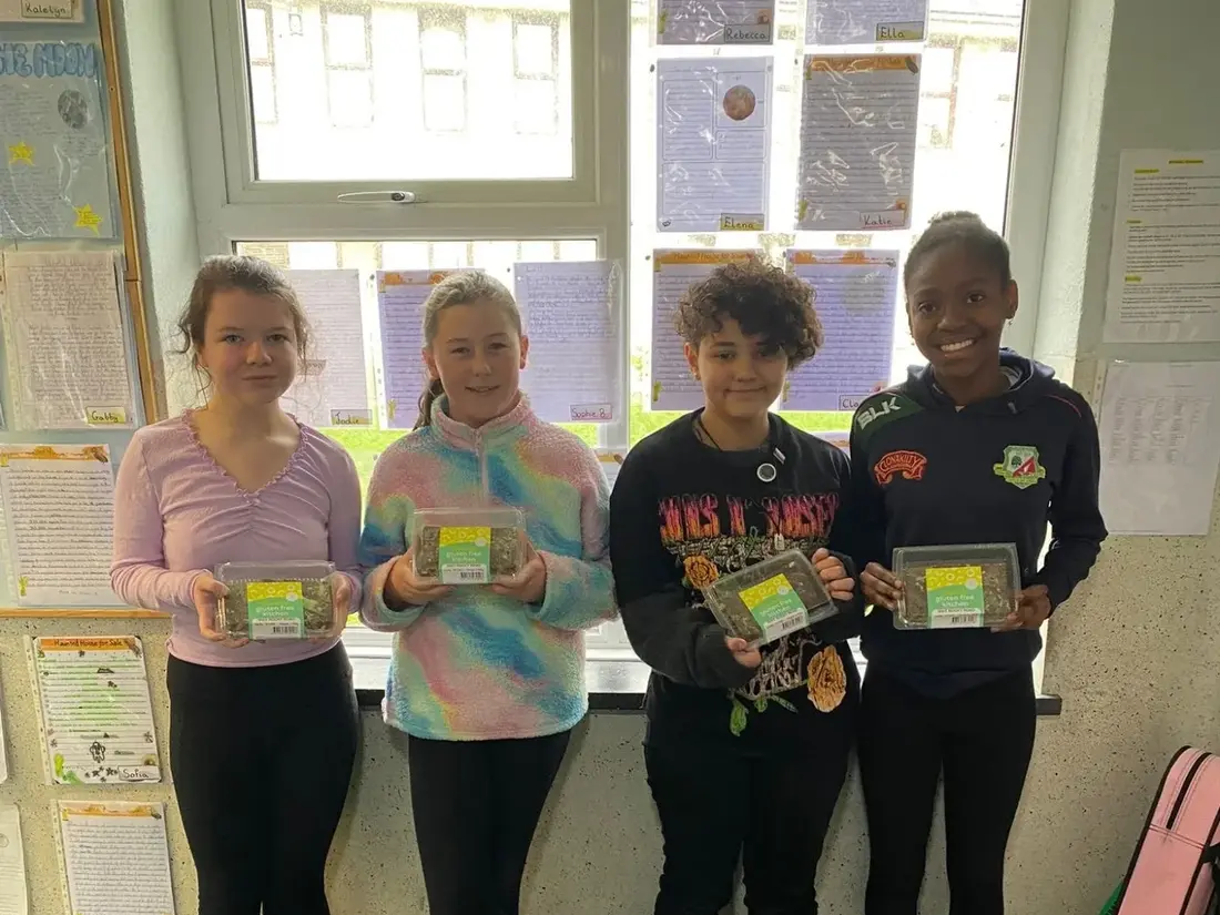 Four pupils holding the boxed product from their Junior Entrepreneur company
