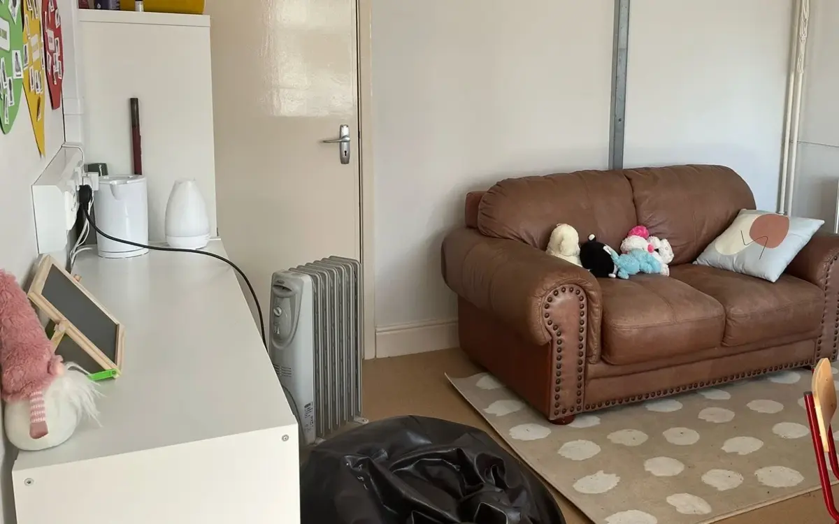 The Nurture Room: a calm space with a sofa, rug, beanbag, round table and soft toys