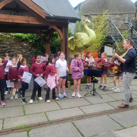 Pupils singing and playing guitar on the street at the Clonakilty International Guitar Festival (photo 4 of 7)