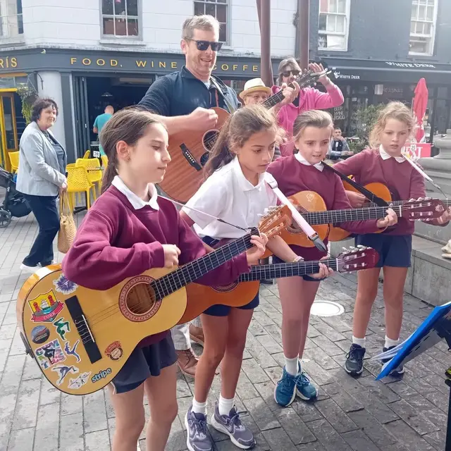 Pupils singing and playing guitar on the street at the Clonakilty International Guitar Festival (photo 1 of 7)