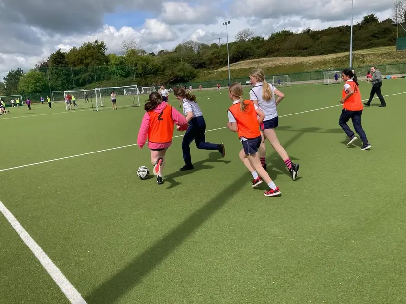 Pupils playing soccer on the astro