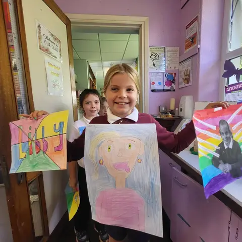 3rd Class pupils holding up their Getting to Know Me artwork (photo 10 of 14)