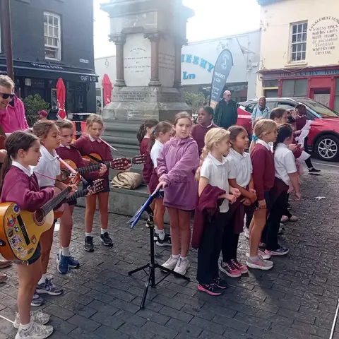 Pupils singing and playing guitar on the street at the Clonakilty International Guitar Festival (photo 3 of 7)