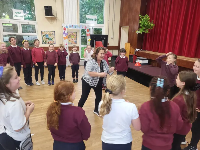 Pupils in a circle in the school hall during a drama workshop