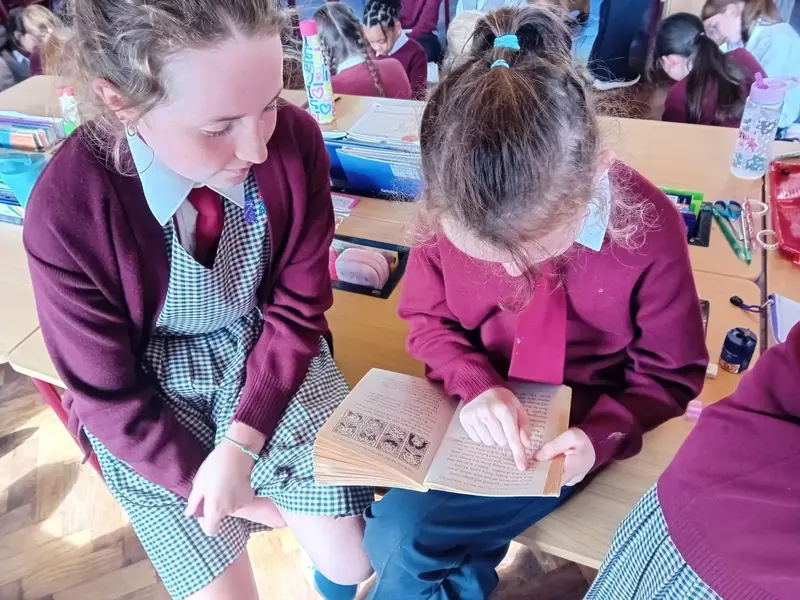 Two pupils reading a book together during buddy reading