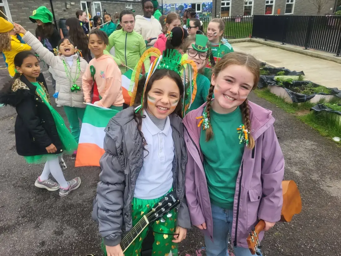 Pupils in green with tricolour face paint and flags on St. Patrick's Day