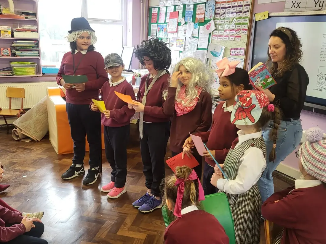 Pupils dressed as book characters reading lines in a classroom