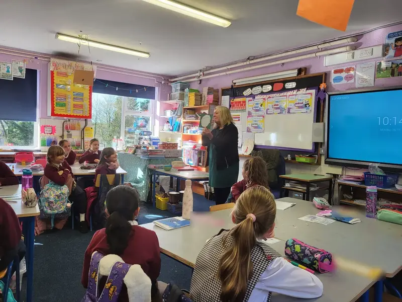 A teacher holding up a card during a language lesson in a classroom