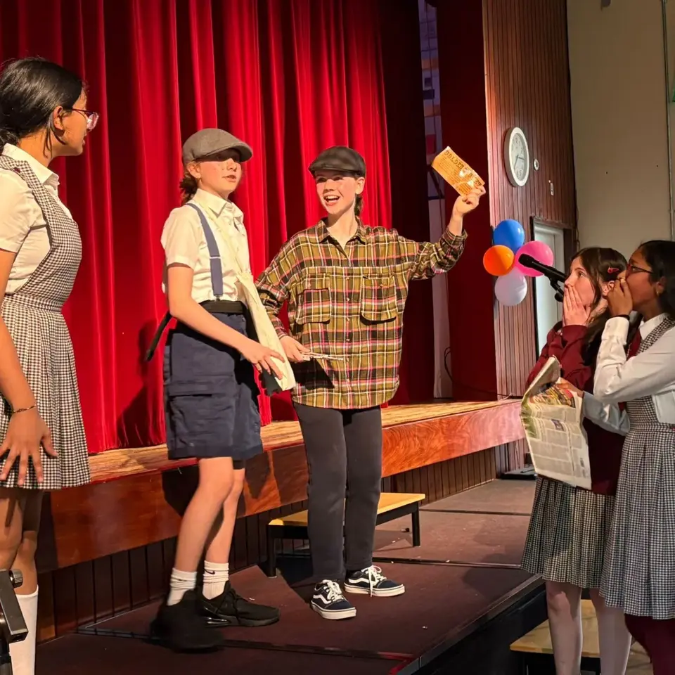 Pupils performing a play on the school stage