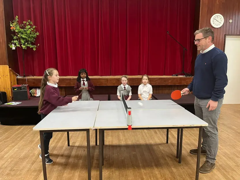 A pupil playing table tennis in the school hall