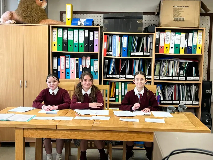 Three pupils at a table during a debate