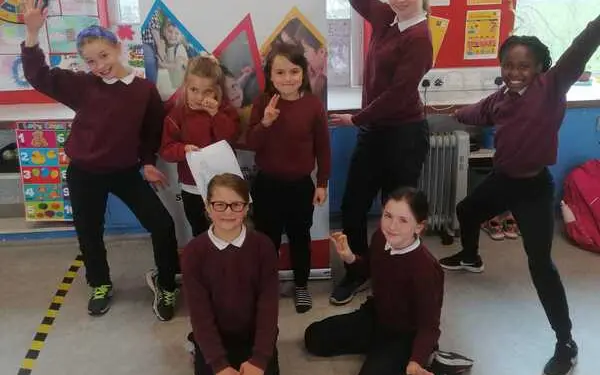 Pupils posing in front of a Sherpa Kids banner: Breakfast Club, After School Care & Holiday Care
