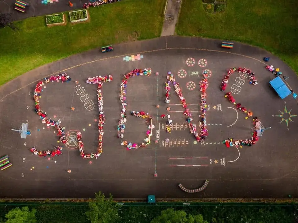 Aerial view of pupils on the school yard spelling out SJGNS