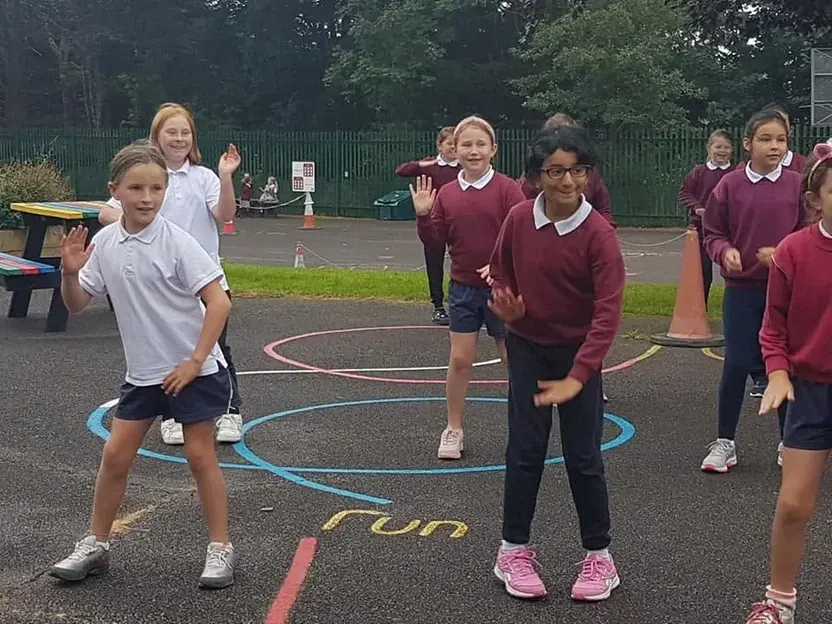 Pupils dancing together on the school yard