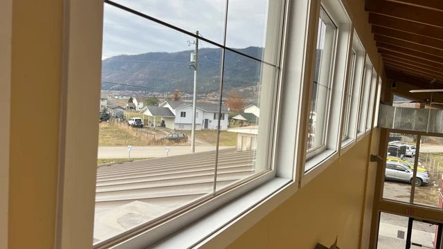 Windows overlooking a Lake Country neighbourhood and hills at a Falconhurst project