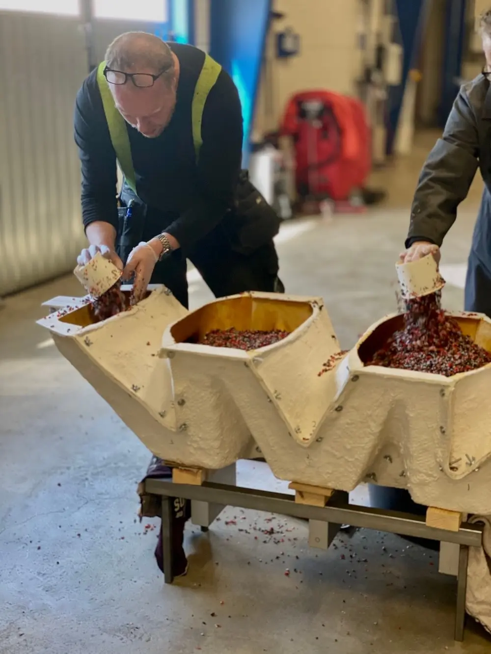Two people pouring material into the zigzag base mould