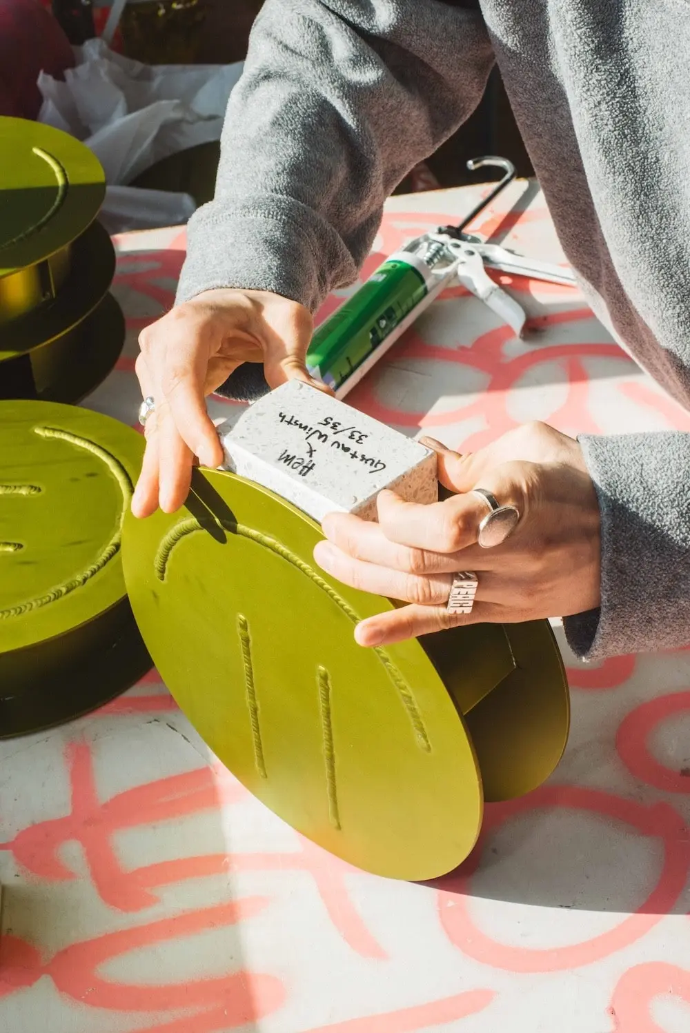 Hands signing a label on an Acid Vase
