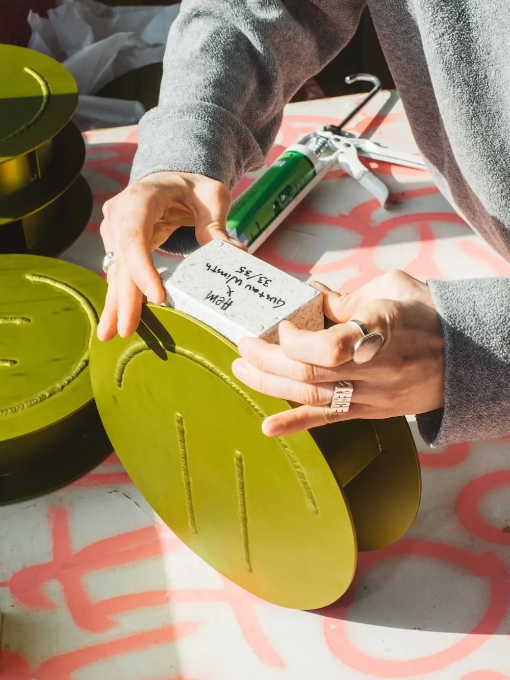 Hands signing a label on an Acid Vase