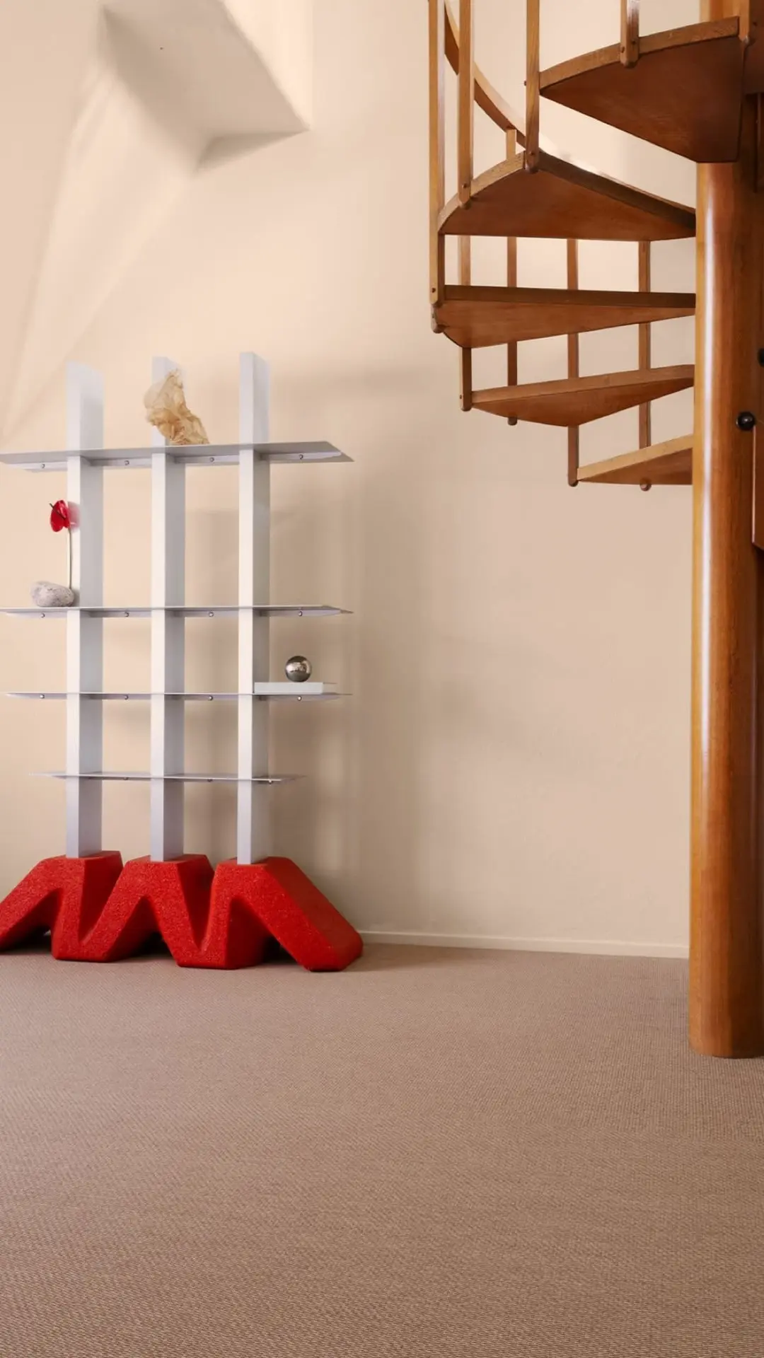 DIO shelf with a red base in a room with a spiral staircase