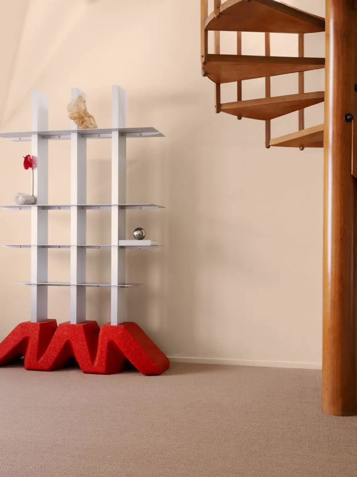 DIO shelf with a red base in a room with a spiral staircase