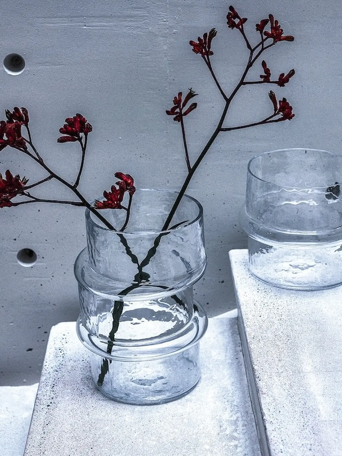 V.GW.01 vase with red-flowered branches on white steps