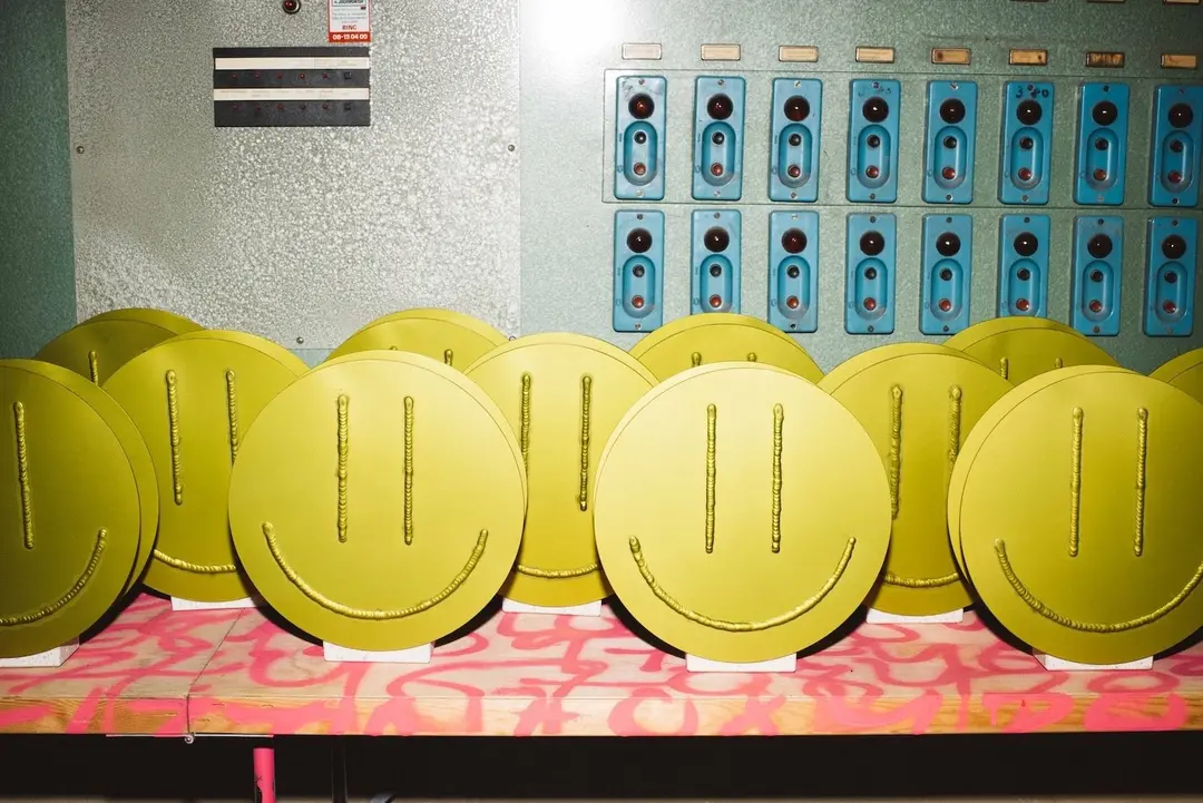 A row of yellow Acid Vases in front of a control panel