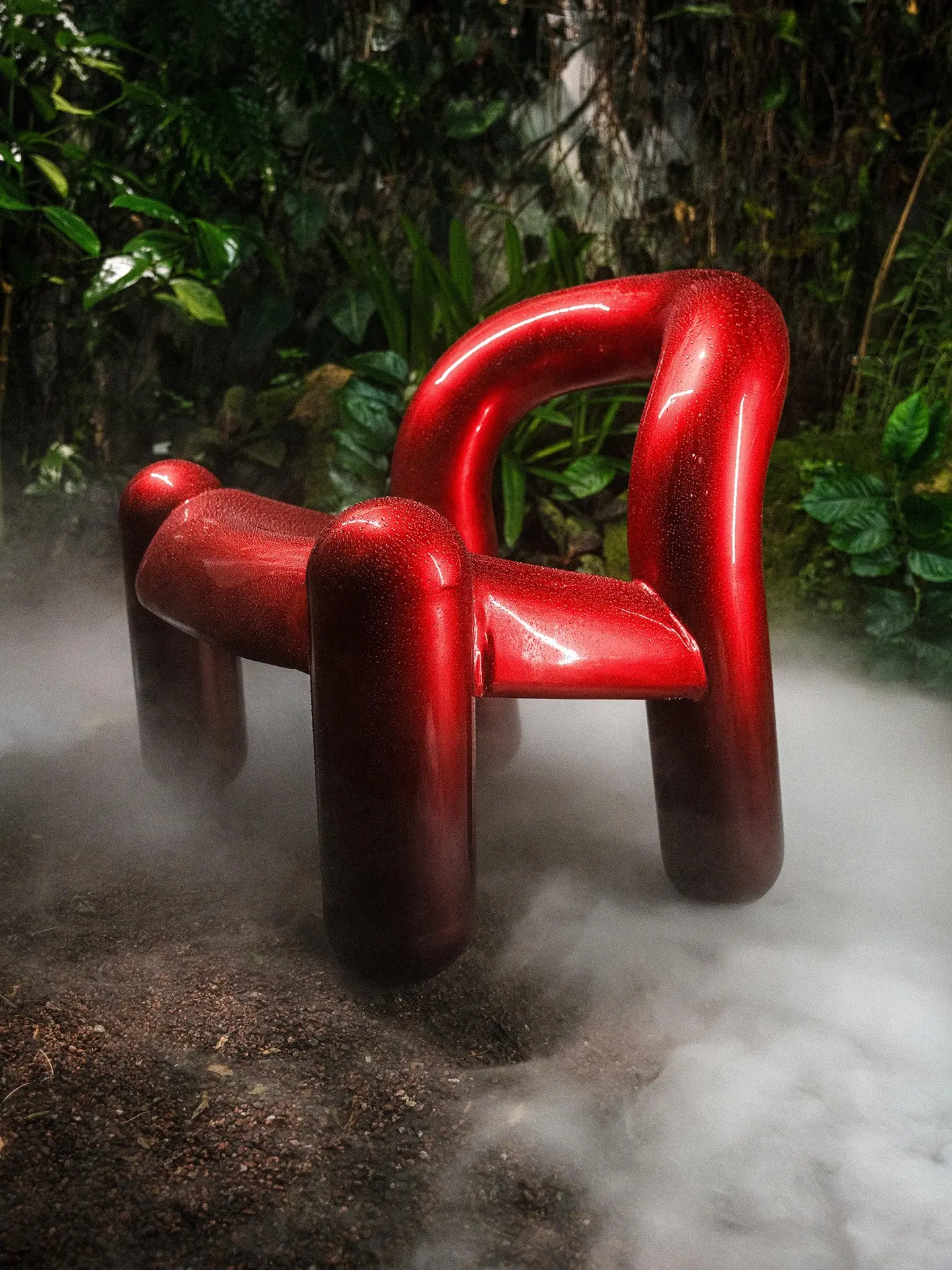 Red Reality armchair in a jungle setting with mist