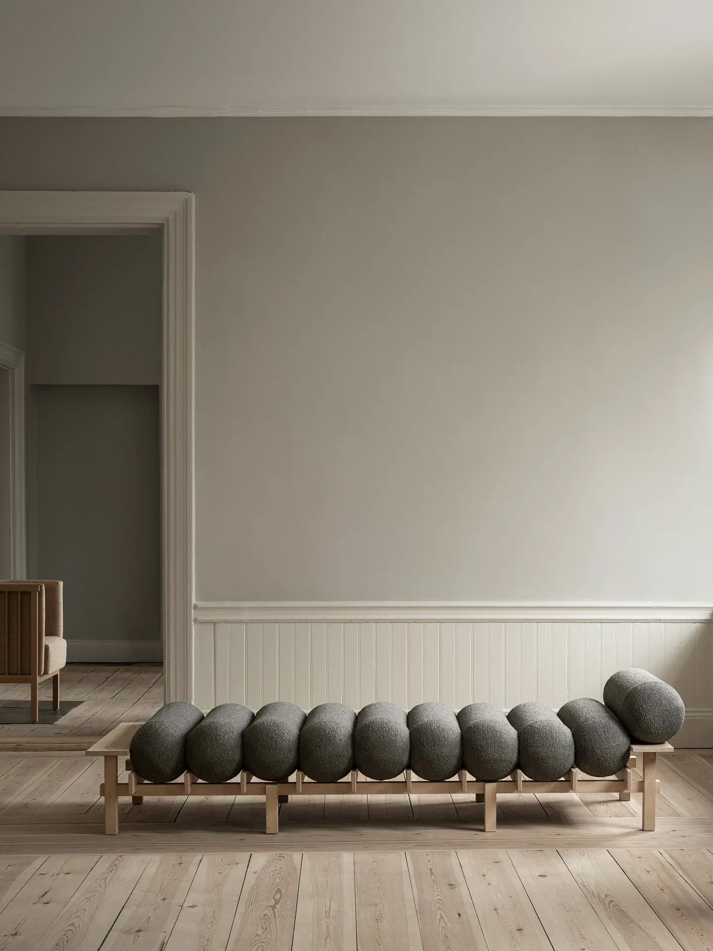 Dag daybed with grey cushions in a bright room with wooden floorboards