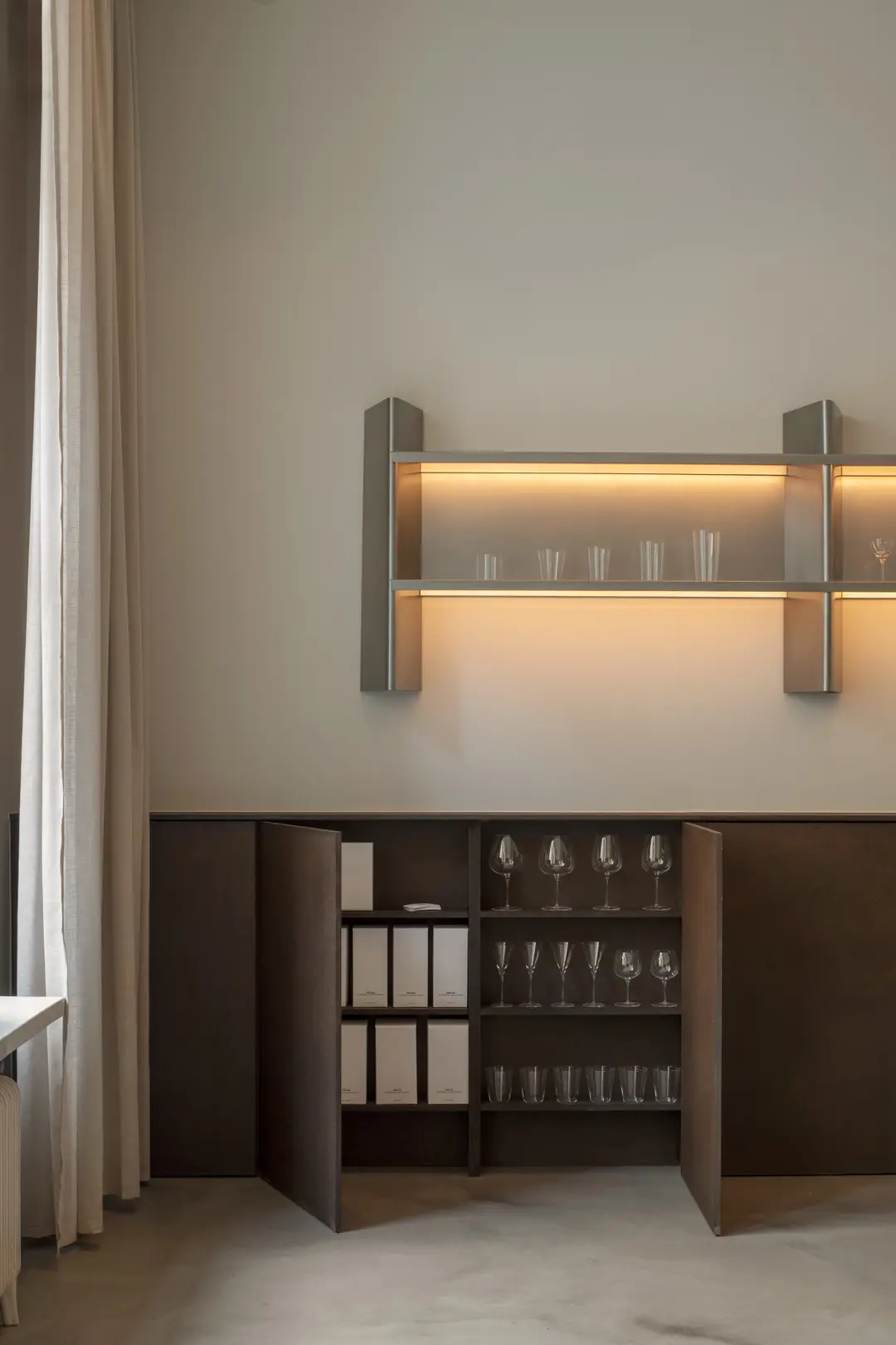 Lit BOBO Shelf with glasses above a dark wooden cabinet
