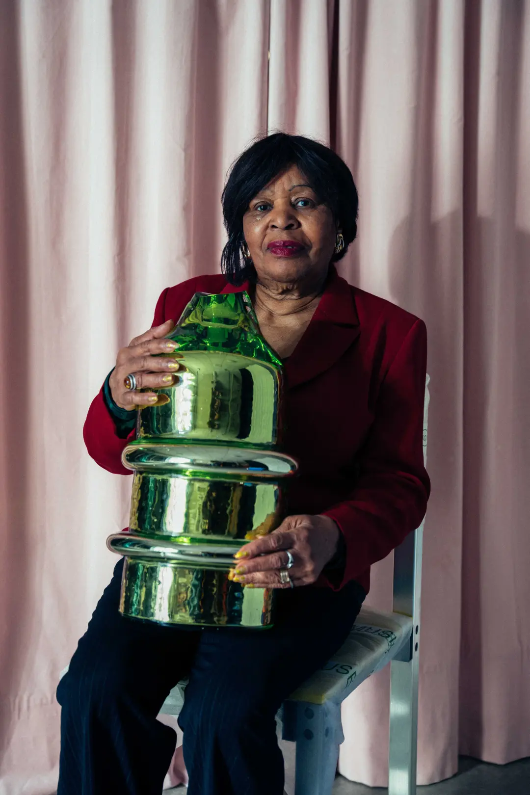 A woman holding a mirrored green Skew sculpture