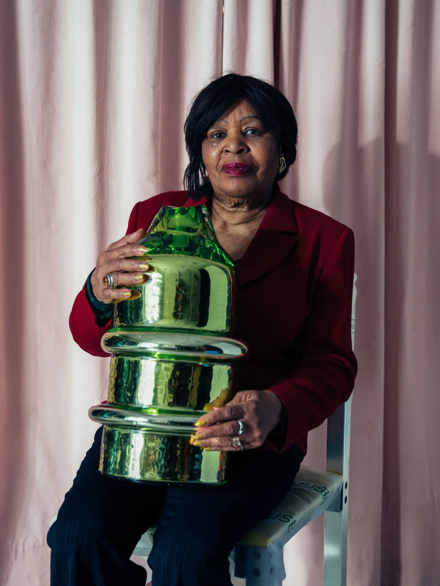 A woman holding a mirrored green Skew sculpture