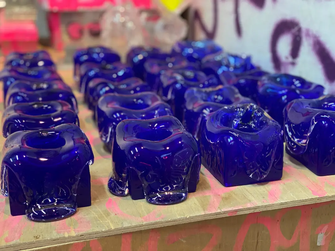 Rows of blue Syrup candleholders on a graffiti table