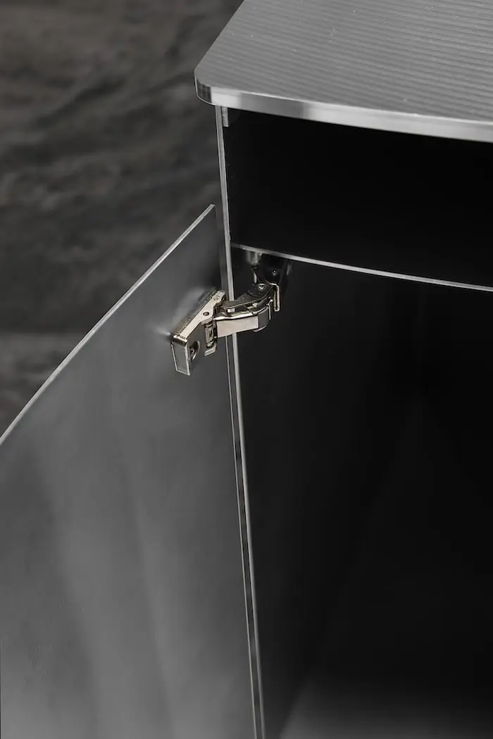 Open aluminium cabinet leg of the desk with its hinge