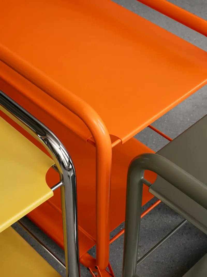 Orange and yellow Tension trolleys, close-up of the bent chrome frame
