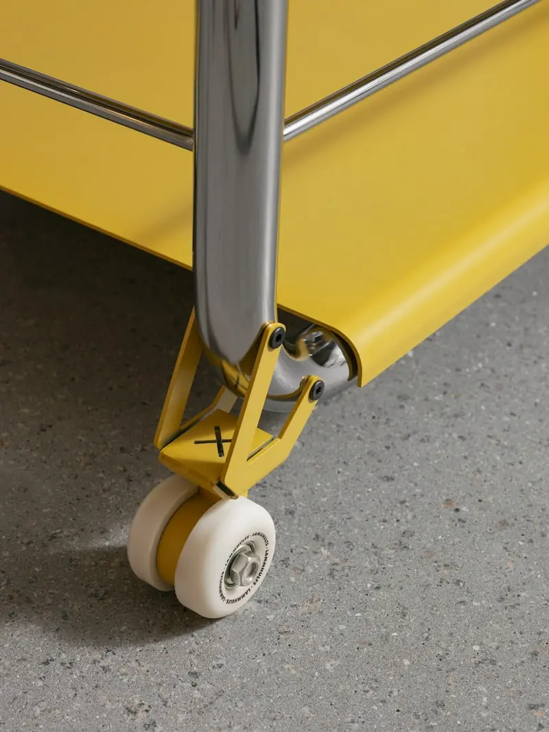 Close-up of a Tension castor below a yellow shelf