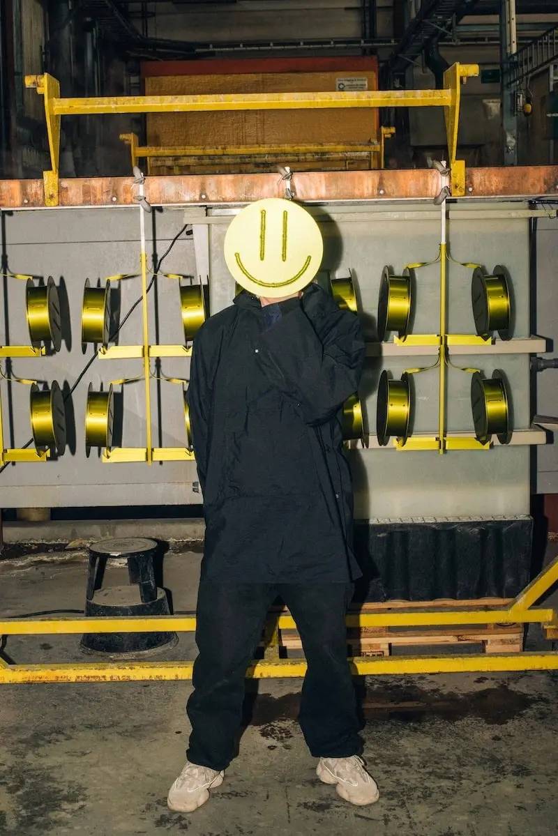 A person holding an Acid Vase in front of their face in the factory