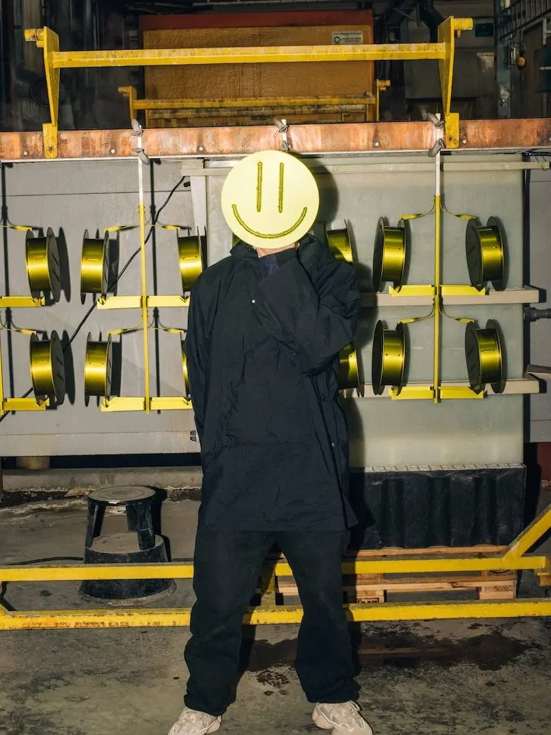 A person holding an Acid Vase in front of their face in the factory