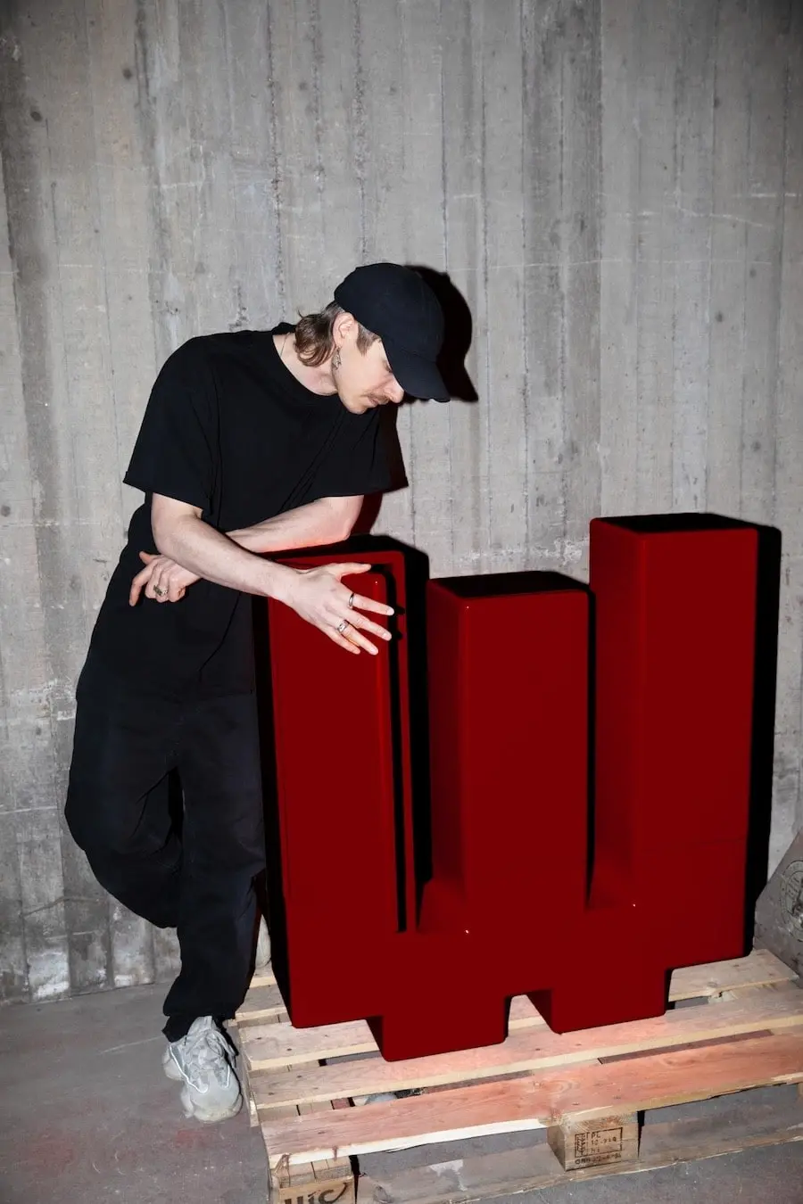 Gustav Winsth leaning on the red Inferno cabinet on a pallet