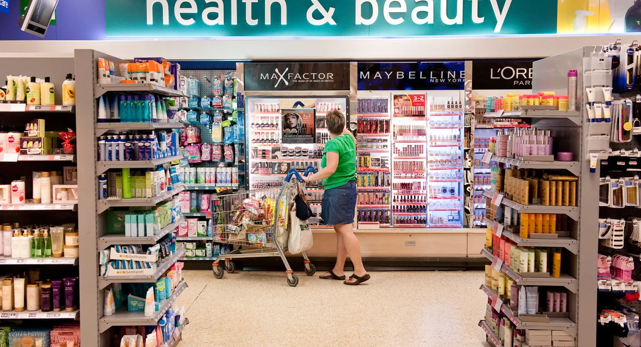 A shopper with a trolley in a supermarket cosmetics aisle