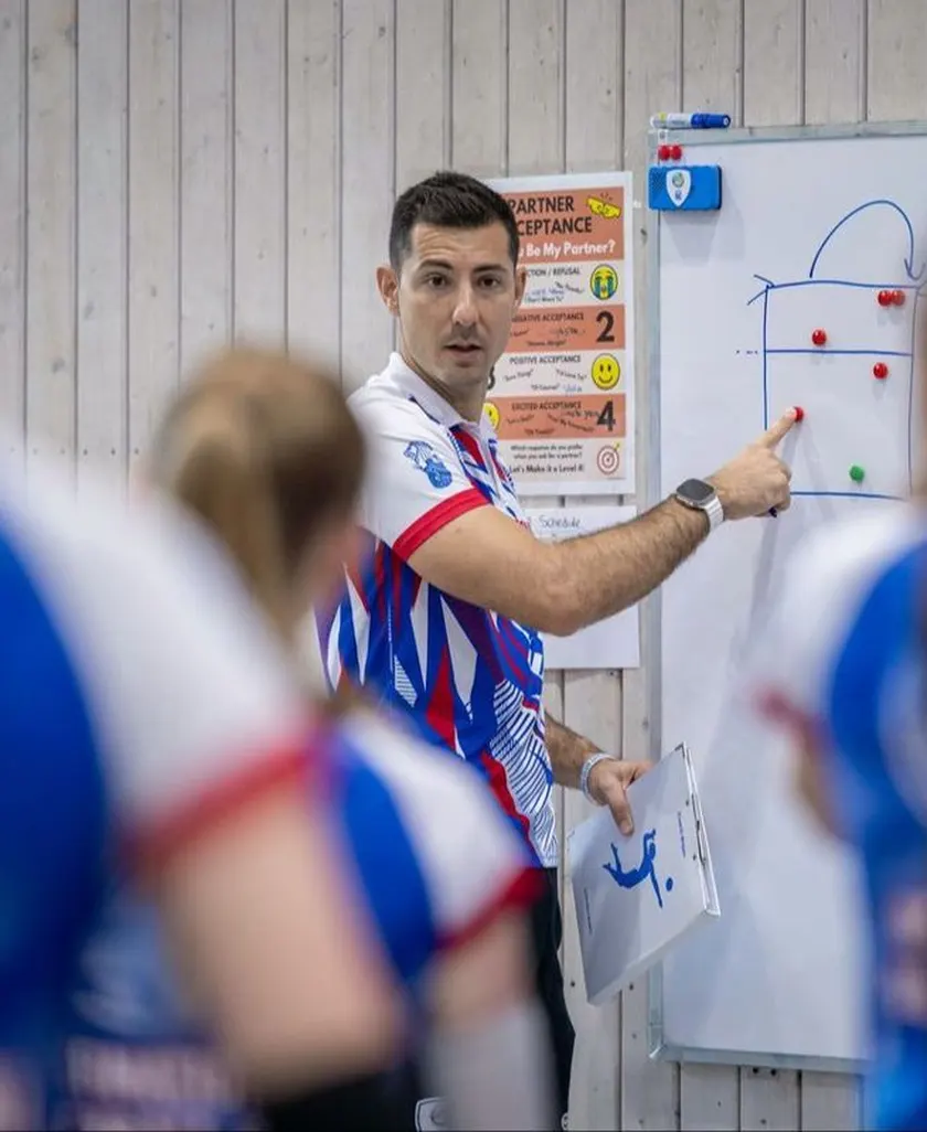 Coach explaining a play on a whiteboard to young players